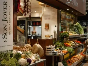 Mercado local de alimentos en Mallorca con productos de temporada, puestos artesanos y residentes haciendo la compra.