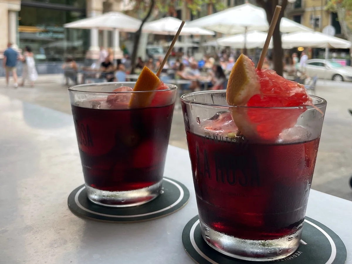 Two glasses of red vermouth served with ice and citrus garnish