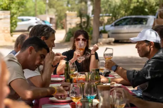 Balearic food producers with artisan cheese, bread and wine on a rustic farm table in Mallorca