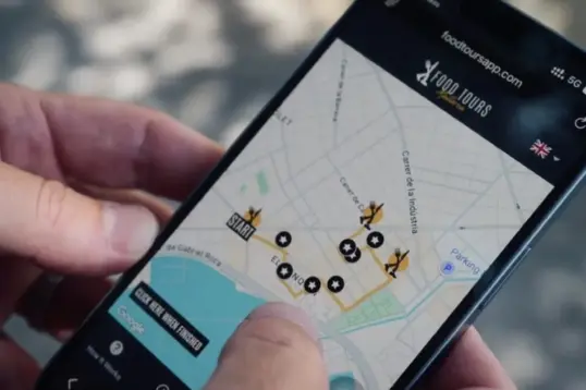 Person following a self-guided food tour route on the Food Tours Balearics web app map in Palma de Mallorca